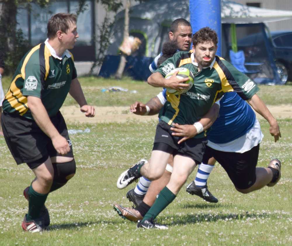 Photo by Jeff Helminiak/Peninsula Clarion Victor Rodriguez of the Kenai River Wolfpack bursts through a tackle while teammate Brian Johnson provides support Saturday at the Kenai Dipnet Fest Rugby 10s Tournament in Kenai.