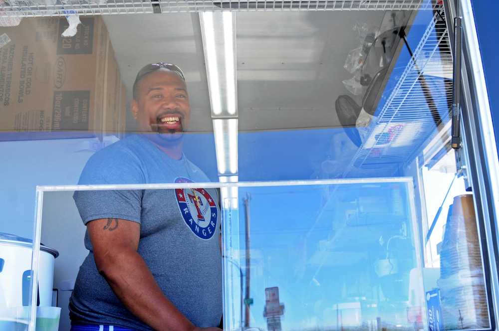 Photo by Elizabeth Earl/Peninsula Clarion Kalani Ross, the owner of Ol' Boy Cuisine, mans his food truck on the north Kenai Beach on Friday, July 15, 2016 in Kenai, Alaska. Ross is among a number of vendors serving the personal use dipnet fishery at the mouth of the Kenai River.