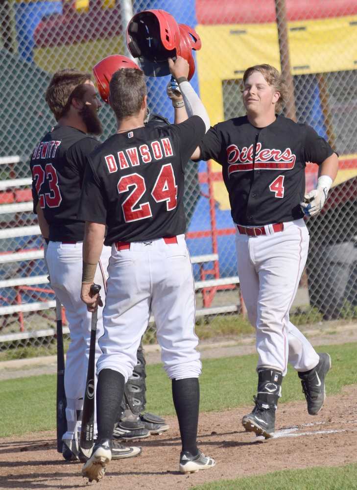 Photo by Jeff Helminiak/Peninsula Clarion Jonathan Washam (4) is congratulated on his two-run home run in the bottom of the first inning by Seth DeWitt and Trey Dawson on Thursday at Coral Seymour Memorial Park in Kenai.