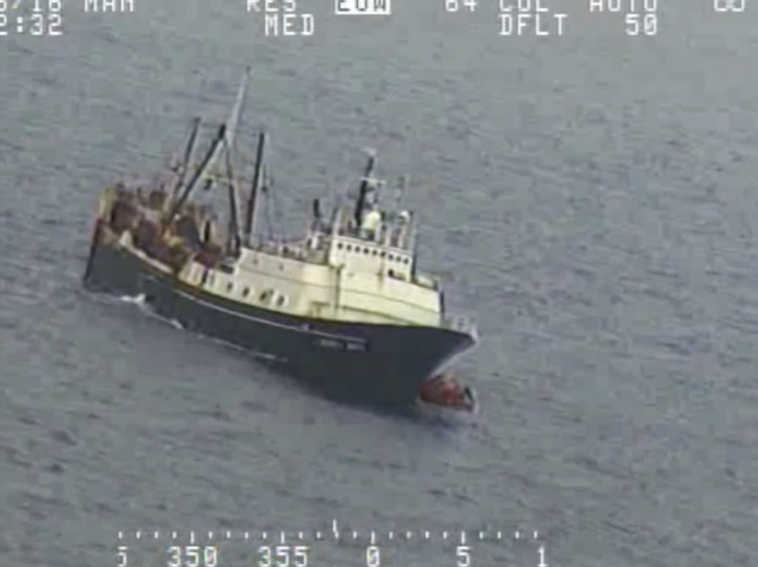 In this Tuesday, July 26, 2016 frame from video provided by the U.S. Coast Guard, crew from a sinking fishing boat, left, board life rafts off Alaska's Aleutian Islands in the Bering Sea. When the Alaska Juris started taking on water Tuesday, crew members donned survival suits and got into rafts. (U.S. Coast Guard via AP)