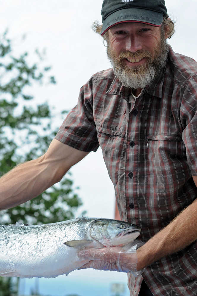 Photo by Elizabeth Earl/Peninsula Clarion Chuck Lindsay displays a salmon on its way to be delivered to a customer on Tuesday, July 26, 2016 in Soldotna, Alaska. Lindsay, one of the owners of Kenai Wild Salmon Co., is a direct seafood marketer, taking part of his catch directly to customers rather than going through a processor.