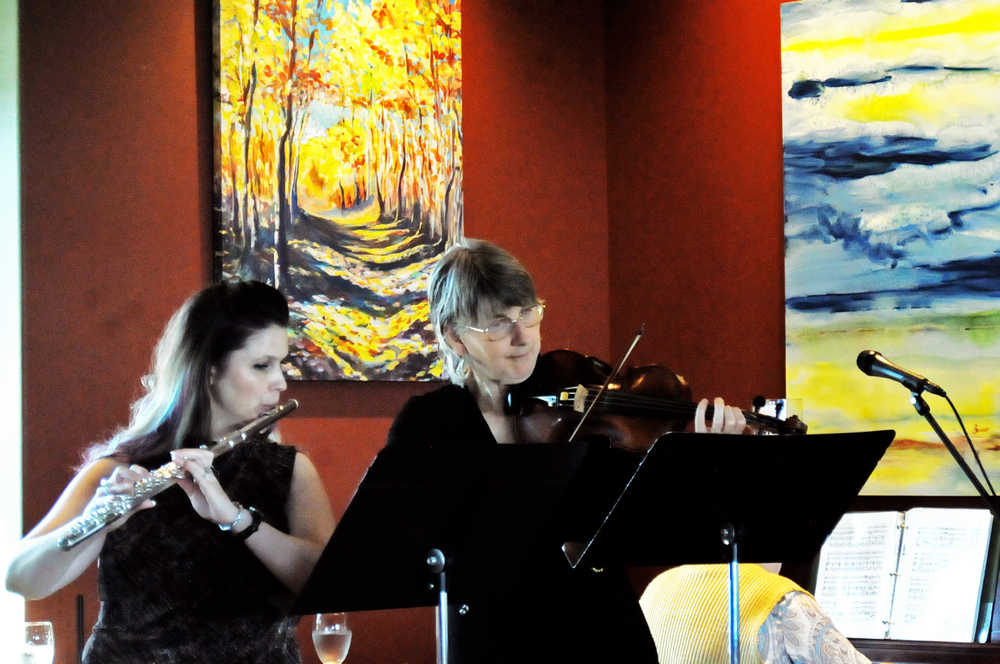 Photo by Elizabeth Earl/Peninsula Clarion Sue Biggs (right) plays the fiddle with flautist Mi'shell French (right) during a noon concert on Wednesday, Aug. 3, 2016 at the Flats Bistro in Kenai, Alaska. Biggs and French join a host of other musicians playing daily concerts on the central and southern Kenai Peninsula for the annual Summer Music Festival, which features a variety of musicians from the Kenai Peninsula Orchestra as well as guest artists from Alaska and elsewhere.