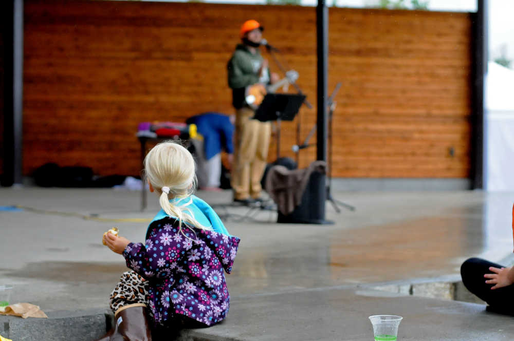Photo by Elizabeth Earl/Peninsula Clarion Drew Slegers, 4, looks on as Dan Pascucci, the education specialist for the Kenai Watershed Forum, performs a set of his science education songs at a farewell party for him Friday, Aug. 5, 2016 at Soldotna Creek Park in Soldotna, Alaska. After 10 years, Pacucci will leave the local conservation organization to take a job in Kentucky.