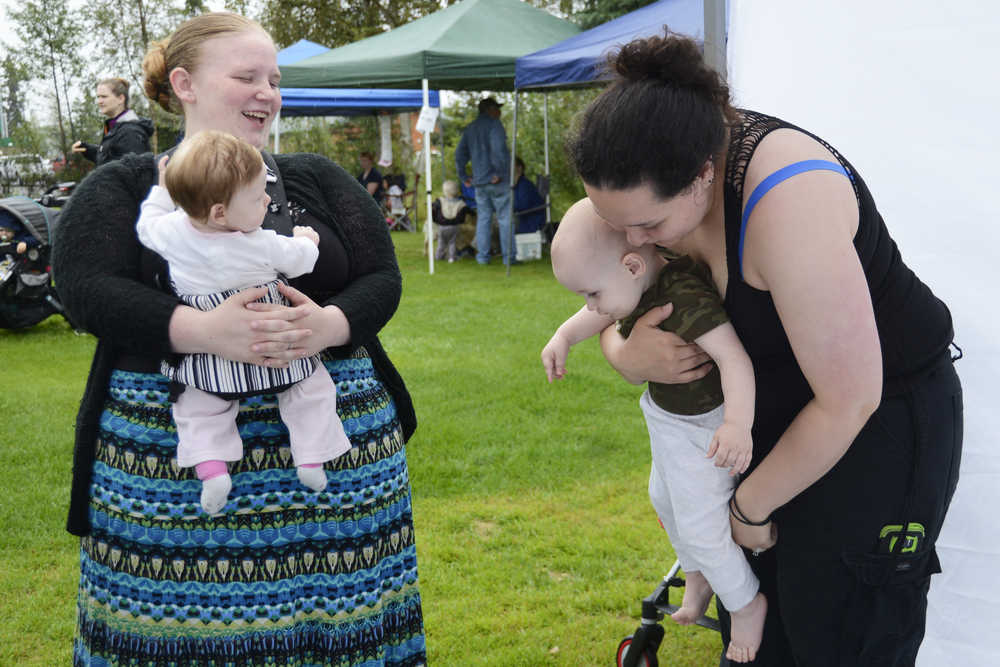 Photo by Megan Pacer/Peninsula Clarion  Kassandra Anderson, left, holds 4-month-old Jolene Payton while Susanne McCarty lets 1-year-old Damien Barbour down to exlpore Saturday, Aug. 6, 2016 during The Global Big Latch On, held locally at Farnsworth Park in Soldotna, Alaska. The event raises awareness and support for breatsfeeding moms worldwide.