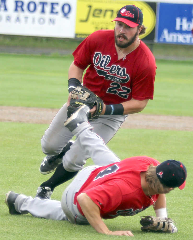 After fielding a bunt, Peninsula second baseman Marshall Boggs tries not to trip over first baseman Jonathan Washam, who slipped to the grass, during a 9-4 Oilers loss to Mat-Su Sundy, Aug. 7, 2016, in the Alaska Baseball League Top of the World Series. The Miners clinched the 2016 ABL title with the win.