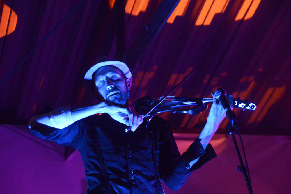 Photo by Megan Pacer/Peninsula Clarion Shane Borth, a violinist and composer for Quixotic, plays during the group's performance Sunday, Aug. 7, 2016 at Salmonfest in Ninilchik, Alaska. Quixotic is a cirque nouveau that blends live music with dance, lights and other performance art.