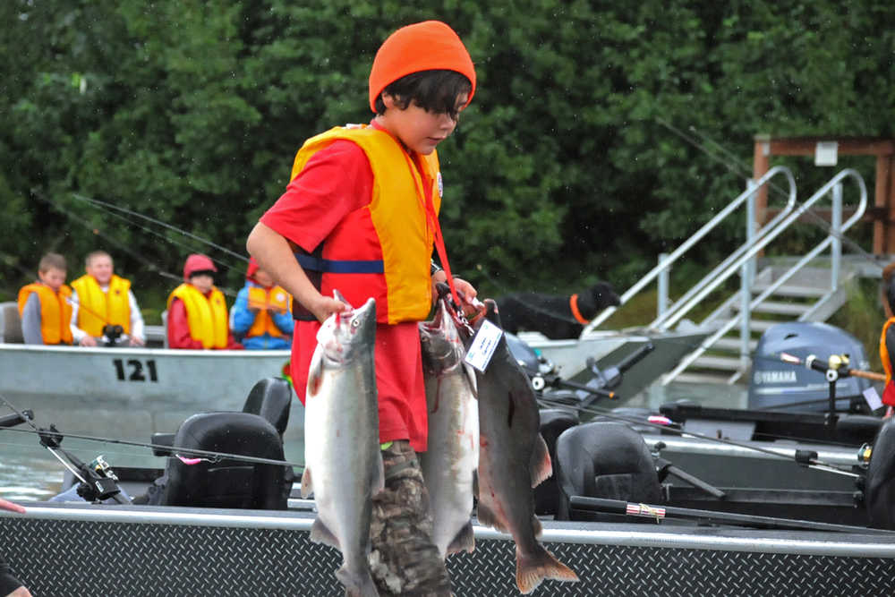 Photo by Elizabeth Earl/Peninsula Clarion Jaden Garner unloads the three salmon he caught from the boat at Centennial Campground's boat launch during the annual "Take Our Kids Fishing" event sponsored by the Boys & Girls Club and the Kenai River Foundation on Thursday, Aug. 11, 2016 in Soldotna, Alaska. The free event offers kids a chance to learn about the river and go out fishing with guides who volunteer their time.