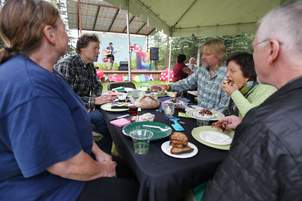 Photo by Kelly Sullivan/ Peninsula Clarion Attendees of the Farm to Table Supper event chow down on menu items made 100 percent from local ingredients by the Willow King, owner of the Where It's At! food bus, and her team of cooks for the Kenai Local Food Connection's third annual Harvest Moon Festival on Sunday, Aug. 14, 2016 in Soldotna, Alaska.