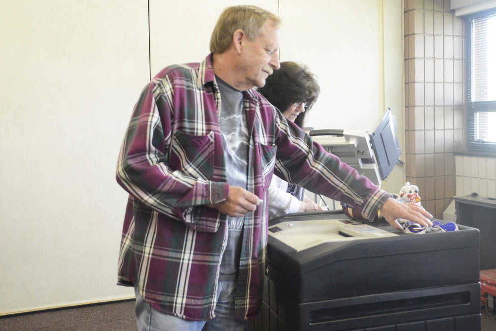 Photo by Megan Pacer/Peninsula Clarion Soldotna residents Tom Huff, foreground, and Hope Haselow, background, pick up stickers that read "I voted today" after turning in their ballots during the state primary election Tuesday, Aug. 16, 2016 at the Soldotna Regional Sports Complex in Soldotna, Alaska. Compared to last year, organizers said voter turnout at the complex was slow throughout the morning and early afternoon.