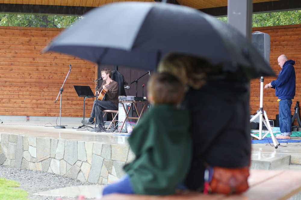 Photo by Kelly Sullivan/ Peninsula Clarion Dietrich Muller, 5, and his grandmother Rebecca Lambourn were of the few that braved heavy rains to watch their good friend Ryan Hiller perform Wednesday, Aug. 17, 2016 at the Soldotna Farmer's Market in Soldotna, Alaska.