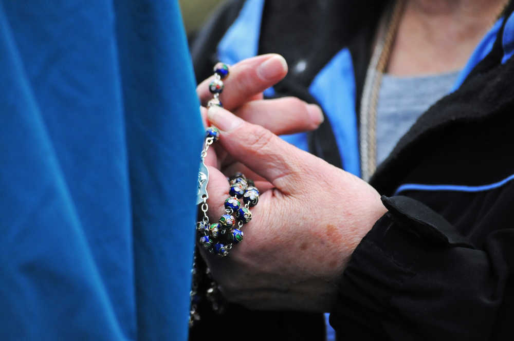 Photo by Elizabeth Earl/Peninsula Clarion A member of the Catholic Church holds her rosary as she prays near a Planned Parenthood clinic on Wednesday, Aug. 17, 2016 in Soldotna, Alaska. Members of the church gathered at the clinic before walking to the Kenai Peninsula Borough Administration Building to pray after a Satanic invocation was given to open the Aug. 9 borough assembly meeting.