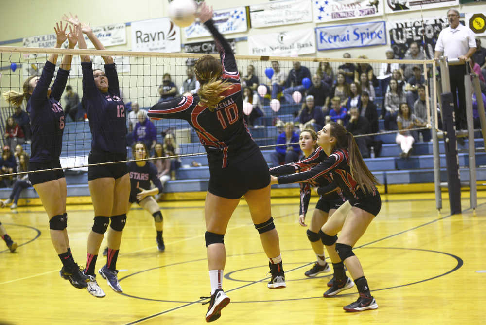 Ben Boettger/Peninsula Clarion Soldotna volleyball players Kearstin Yarnes (left) and Drewe Zeek leap to block a volley by Kenai's Abby Beck during a game at Soldotna High School on Friday, Oct. 30.