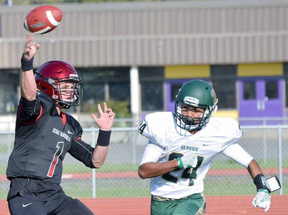 Photo by Jeff Helminiak/Peninsula Clarion Kenai Central quarterback Chase Gillies passes under pressure from Service's Dominik Norman on Friday at Ed Hollier Field in Kenai.