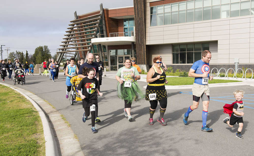 Racers run past the Kenaitze Indian Tribe's Dena'ina Wellness Center at the start of the CASA Superhero 5-kilometer run/walk on Saturday morning. The event raised funds for the tribe's Court Appointed Special Advocates program.