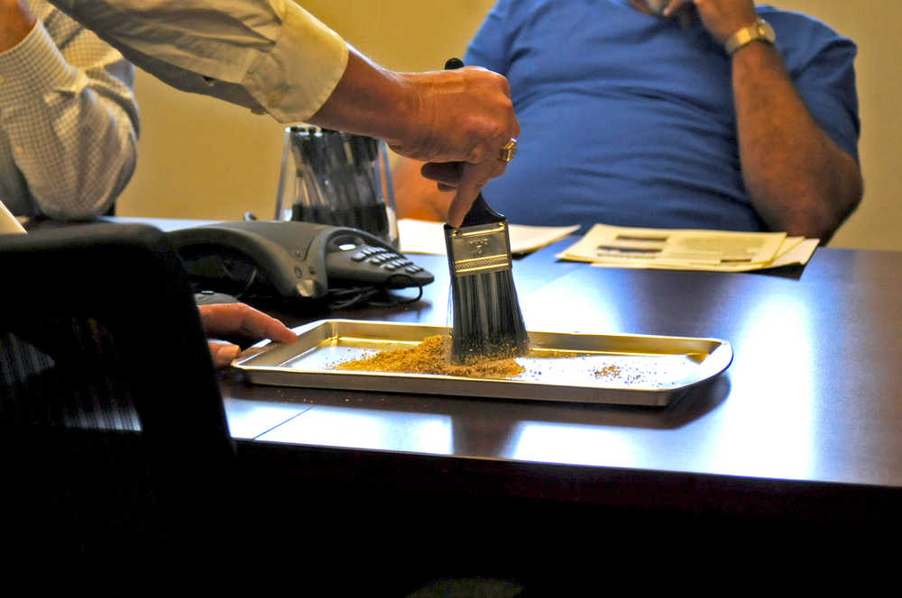 Photo by Elizabeth Earl/Peninsula Clarion David Schmitt, the COO of Industrial Hemp Manufacturing in Spring Hope, North Carolina, demonstrates how kenaf fiber can absorb spilled oil at the Kenai Peninsula Borough Economic Development District on Tuesday, Aug. 16, 2016. Schmitt said the kenaf fiber, a wood-like plant, can absorb 30 times as much as clay composite, which is regularly used to help clean up land-based oil spills.