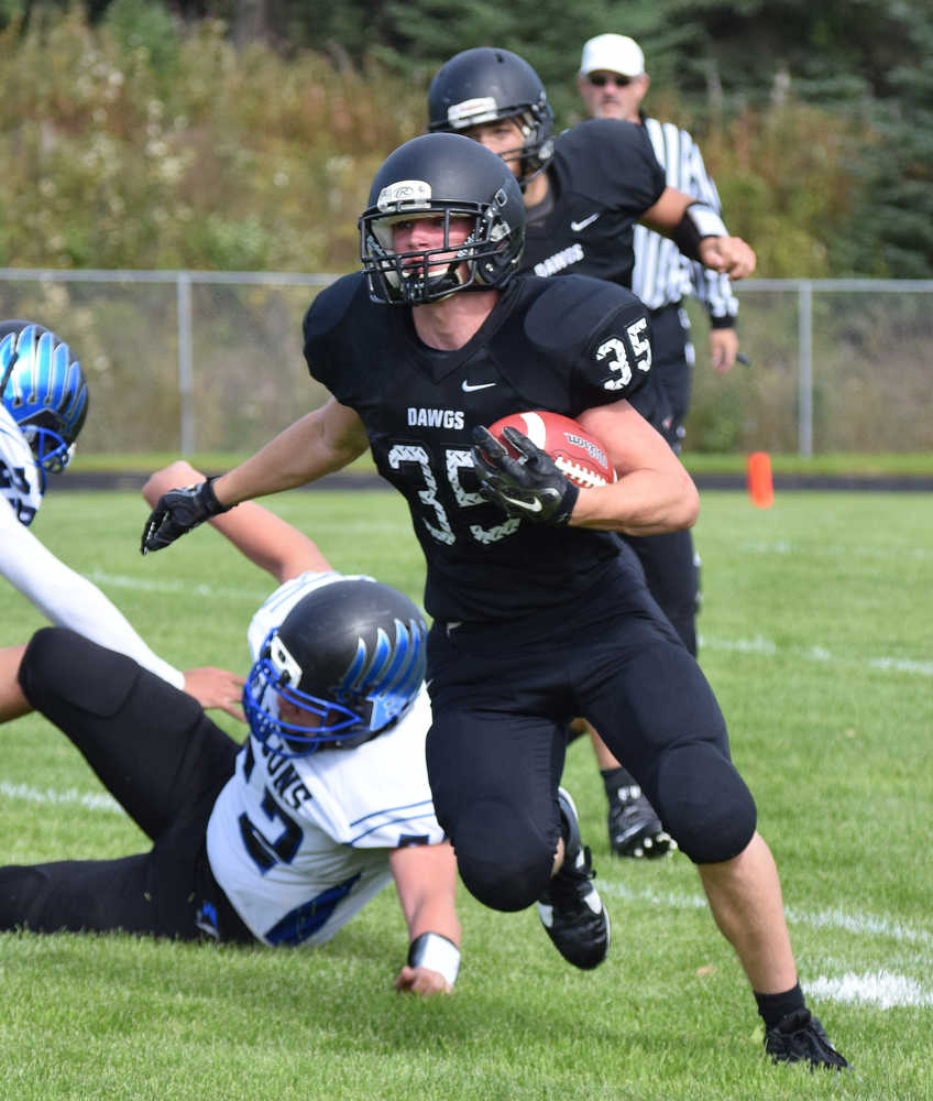 Photo by Joey Klecka/Peninsula Clarion Nikiski senior Patrick Perry takes a handoff from Ian Johnson in a nonconference game against Thunder Mountain Saturday, Aug. 20, at Nikiski High School.