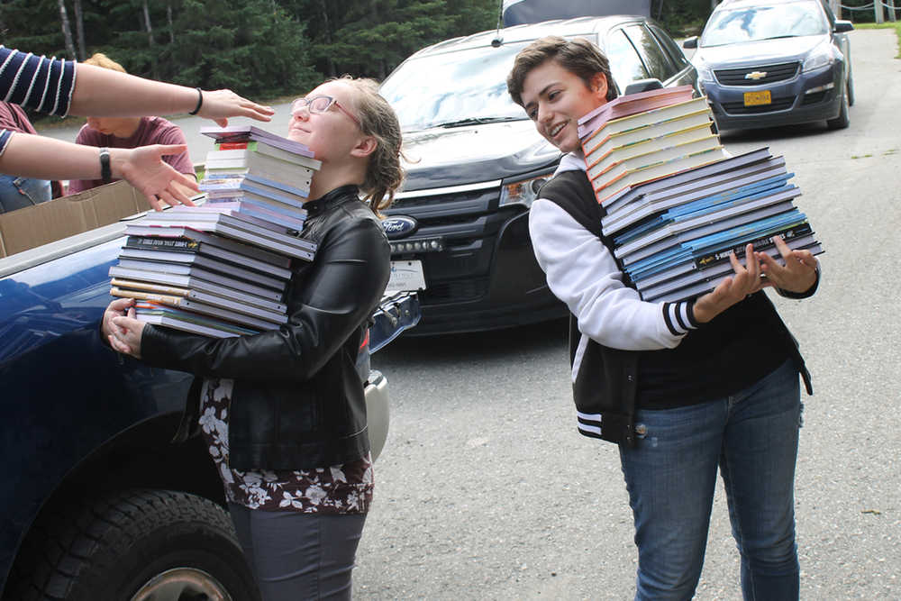 Photo courtesy Joe Rizzo Savannah Rizzo and Sarah Nash carry piles of books into Hope School.