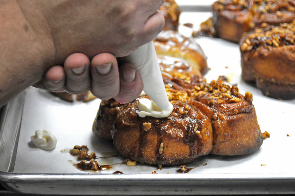 Dave Olson of Double O Express ices a sticky bun at the restaurant on Tuesday, Aug. 23, 2016 at the Kenai Airport in Kenai, Alaska. Olson, who owns the restaurant with his wife Tammy, formerly worked as a chef on the North Slope before opening the restaurant in April 2015.