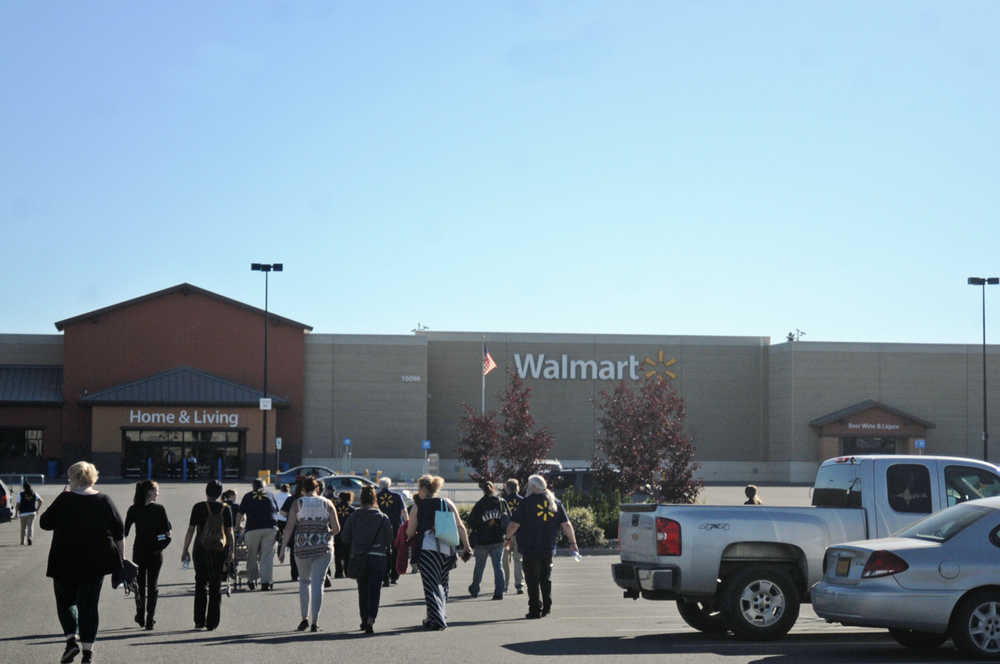 Photo by Elizabeth Earl/Peninsula Clarion Employees and customers of the Kenai Walmart Supercenter return to the  store after being briefly evacuated for a phoned-in bomb threat Monday, Aug. 29, 2016 in Kenai, Alaska. Several others were phoned in to stores in the Anchorage area.
