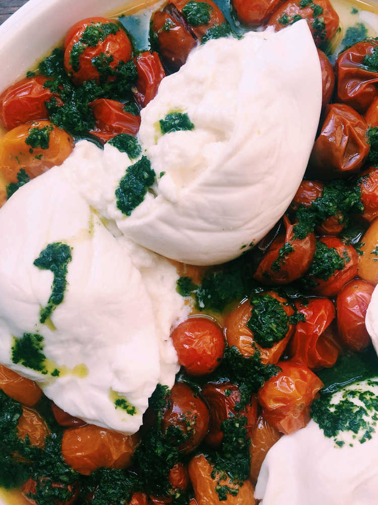 This July 2016 photo shows cherry tomatoes with burrata in New York. This dish is from a recipe by Katie Workman. (Katie Workman via AP)