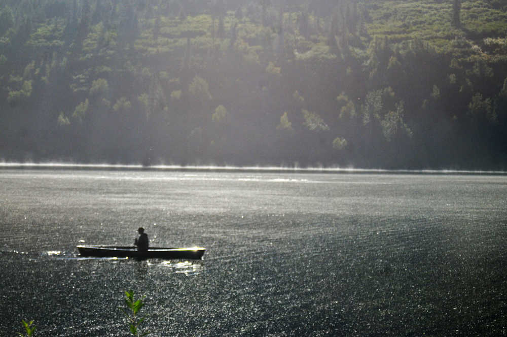 Photo by Elizabeth Earl/Peninsula Clarion A man rows his way across Lower Summit Lake on a sunny morning Sunday, Aug. 28, 2016 on Alaska's Kenai Peninsula.