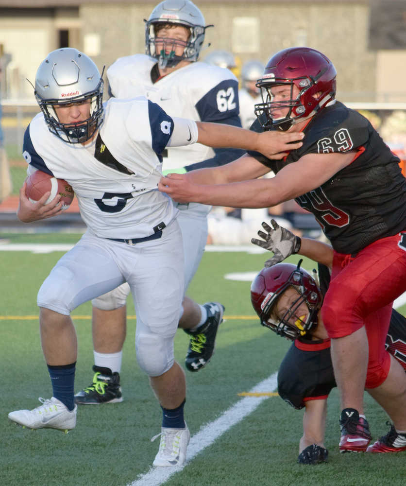 Photo by Jeff Helminiak/Peninsula Clarion Eagle River's Grant Burningham is brought down on a kickoff return by Kenai Central's James Siamani and Tristan Landry on Friday at Ed Hollier Field in Kenai.