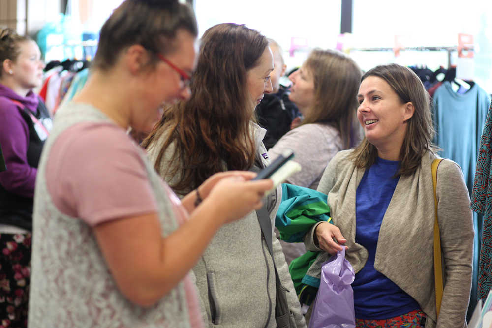 Photo by Kelly Sullivan/ Peninsula Clarion (Middle) Nicole Erb chats with a friend while event organizer Kamrei Riley, and individual fashion consultant for California-based clothing company LulaRoe, rings up their purchases at the fundraiser for Kathleen Harrison on Monday, Sept. 5, 2016 at the Soldotna Regional Sports Complex in Soldotna, Alaska.