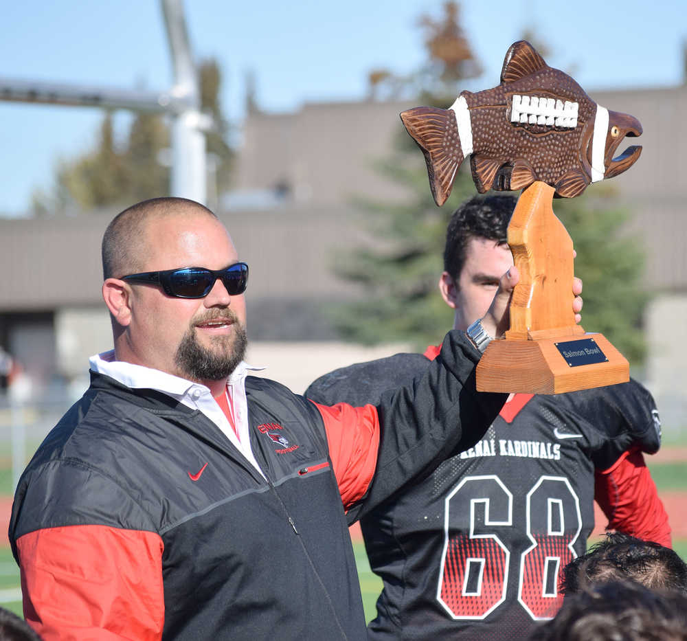 Photo by Joey Klecka/Peninsula Clarion Kenai Central football coach Davis Lowery holds up the "Salmon Bowl" traveling trophy Saturday afternoon after the Kardinals defeated Kodiak at Ed Hollier Field.