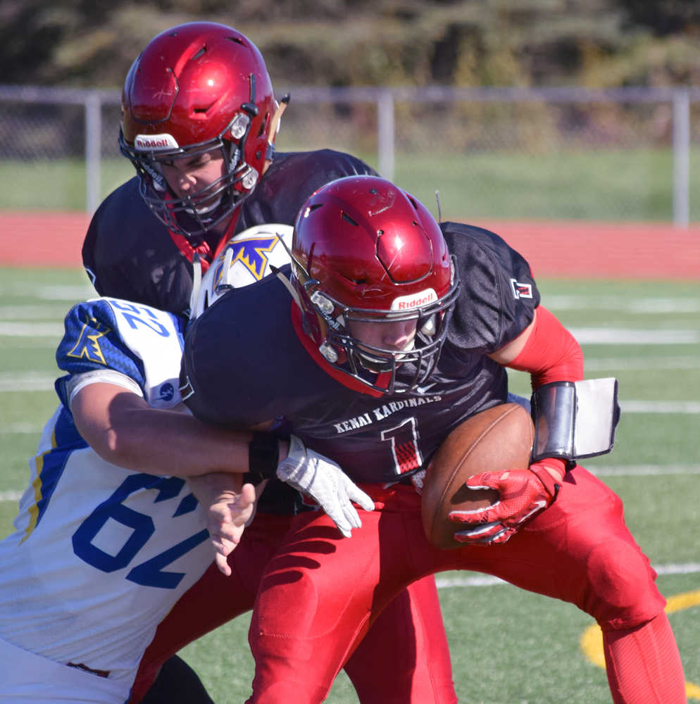 Photo by Joey Klecka/Peninsula Clarion Kenai Central quarterback Chase Gillies tries to avoid getting sacked from Kodiak's Braxton Bolen Saturday afternoon at Ed Hollier Field in Kenai.