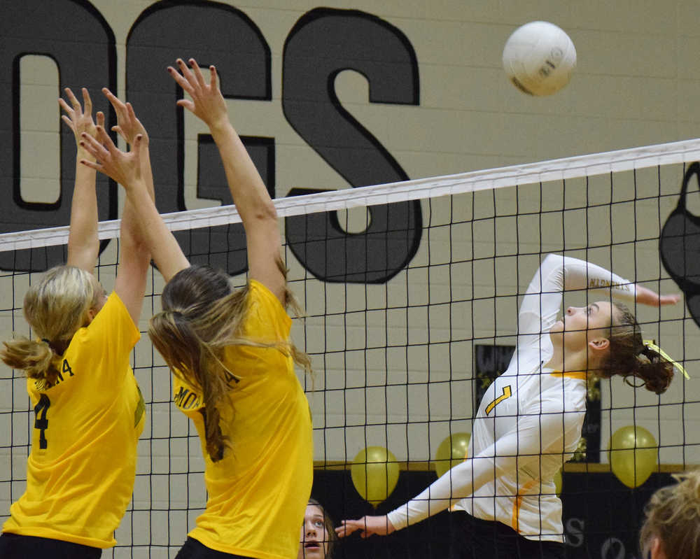 Photo by Joey Klecka/Peninsula Clarion Nikiski sophomore Bethany Carstens winds up for the spike against Kenai Central's Caleigh Jensen (4) and Mayzie Potten Tuesday night at Nikiski High School.