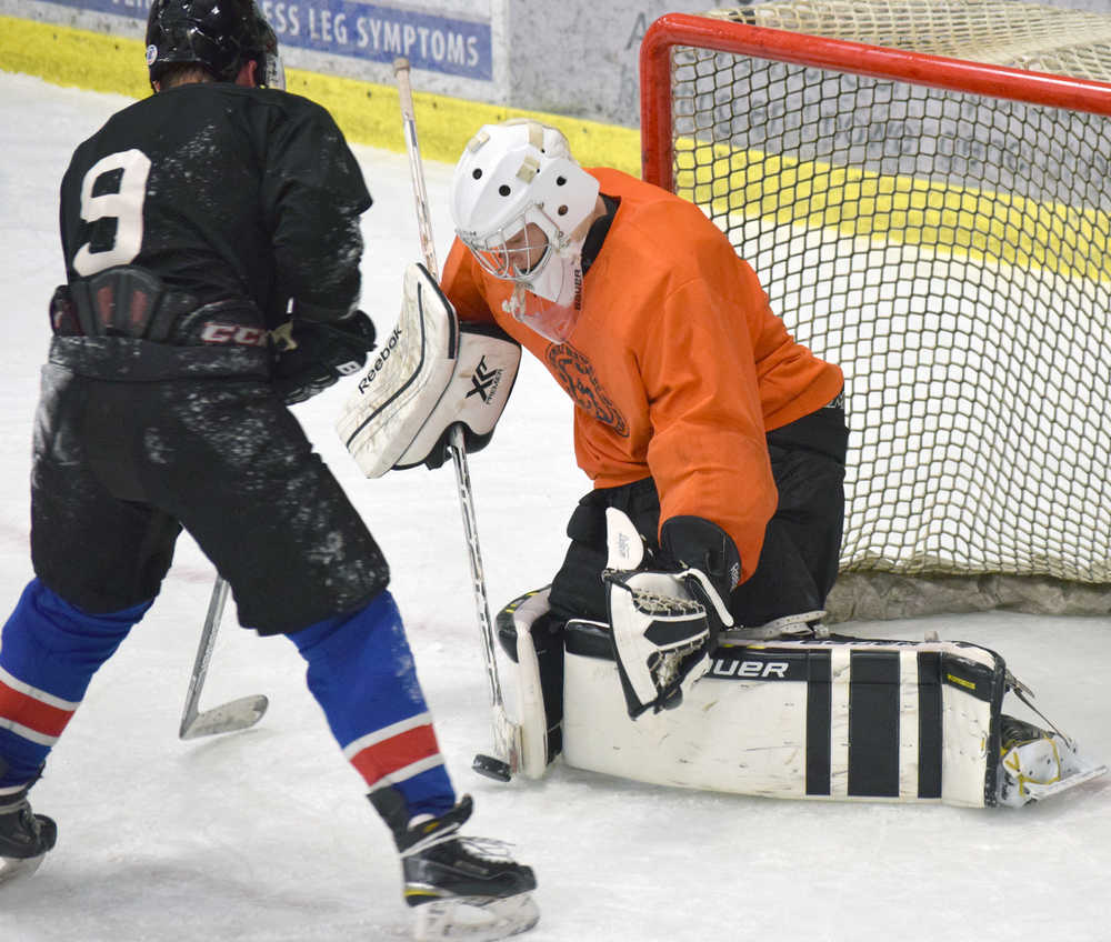 Photo by Jeff Helminiak/Peninsula Clarion Kenai River Brown Bears goalie Connor Poczos makes a save in front of defenseman Sam Sterne during a drill in practice Wednesday at the Soldotna Regional Sports Complex ahead of the team's home opener tonight.