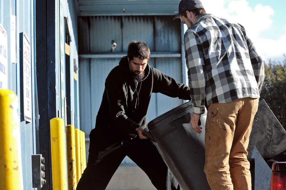 Photo by Elizabeth Earl/Peninsula Clarion Michael Anderson (left) and Jake Graham (right) of Kenai drop off a load of garbage at Central Peninsula Landfill on Wednesday, Sept. 28, 2016 near Soldotna, Alaska. Beginning Sunday, Oct. 2, the landfill will close on Sundays until May as a cost-saving measure.