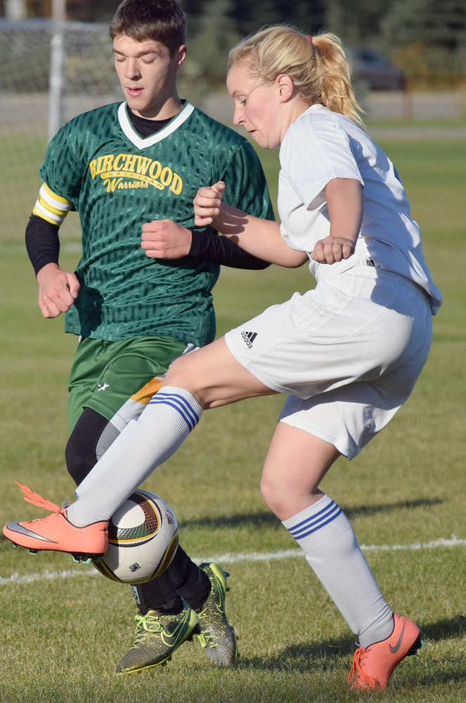 Photo by Joey Klecka/Peninsula Clarion Cook Inlet Academy defenders Adara Warren (white) vies for the ball against Birchwood Christian's Stephen Sterling Thursday morning at the Kenai Sports Complex fields.