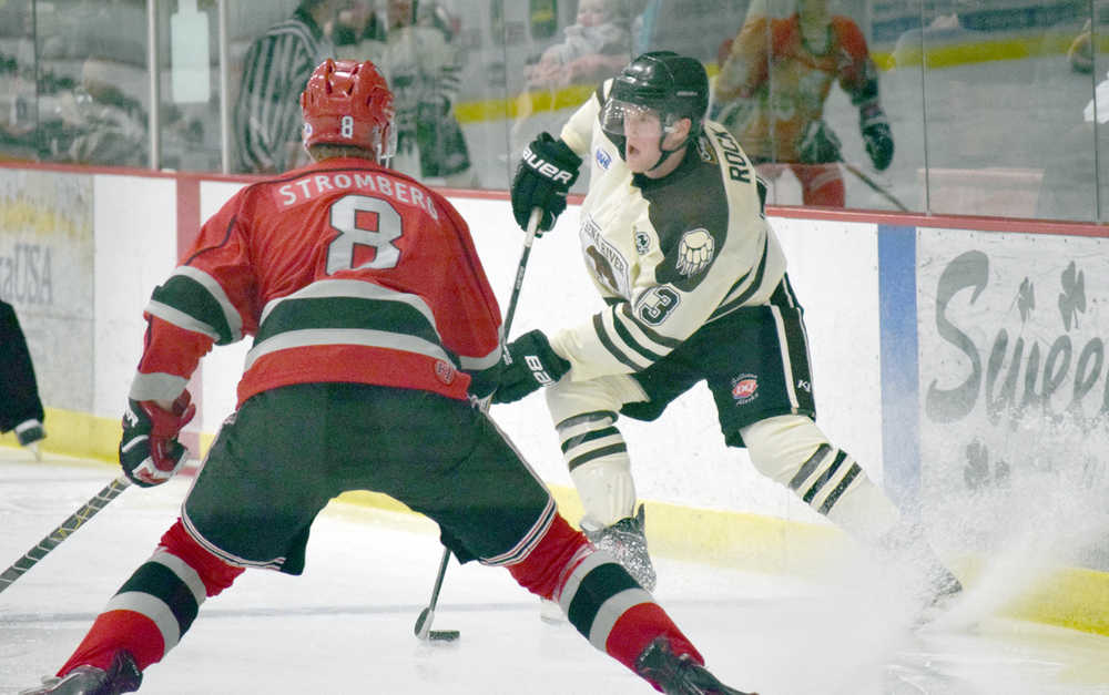 Photo by Jeff Helminiak/Peninsula Clarion Kenai River Brown Bears forward Tyler Rock pulls up in the offensive zone against New Jersey Titans defenseman Oskar Stromberg on Friday at the Soldotna Regional Sports Complex.