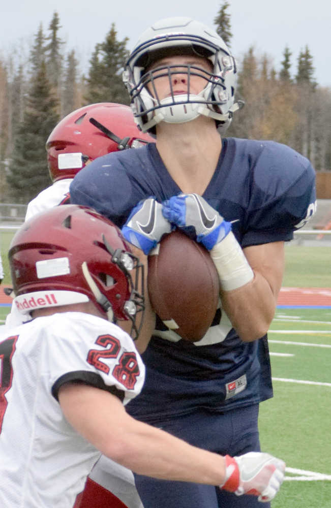 Photo by Jeff Helminiak/Peninsula Clarion Soldotna tight end Andy West hauls in a pass between Rykker Riddall (No. 28) and Chase Gillies on Saturday at Justin Maile Field in Soldotna.