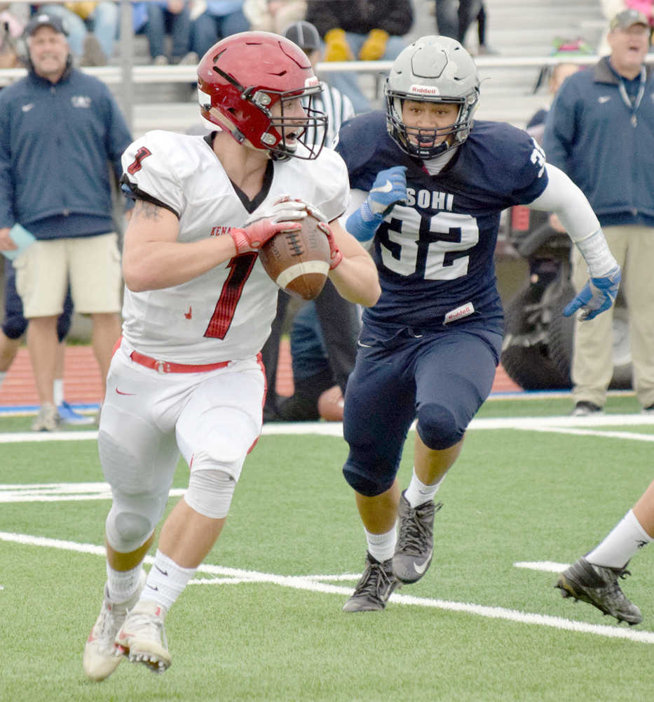 Photo by Jeff Helminiak/Peninsula Clarion Kenai quarterback Chase Gillies scrambles under pressure from Soldotna's Jeremiah Lefao on Saturday at Justin Maile Field in Soldotna.