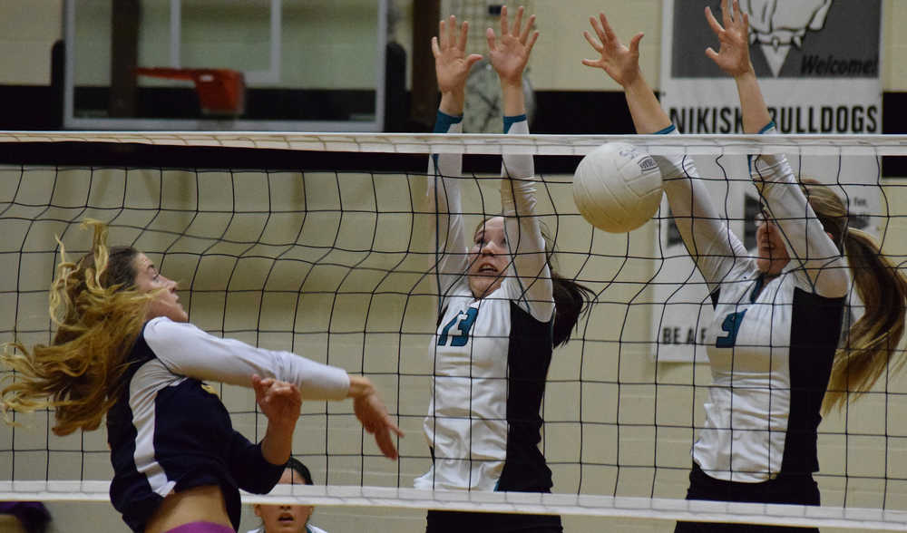 Photo by Joey Klecka/Peninsula Clarion Nikiski middle hitters Maddy Williams (13) and Jamie Yerkes block a shot from Homer's Mary Hana Bowe in a Southcentral Conference game Tuesday night at Nikiski High School.