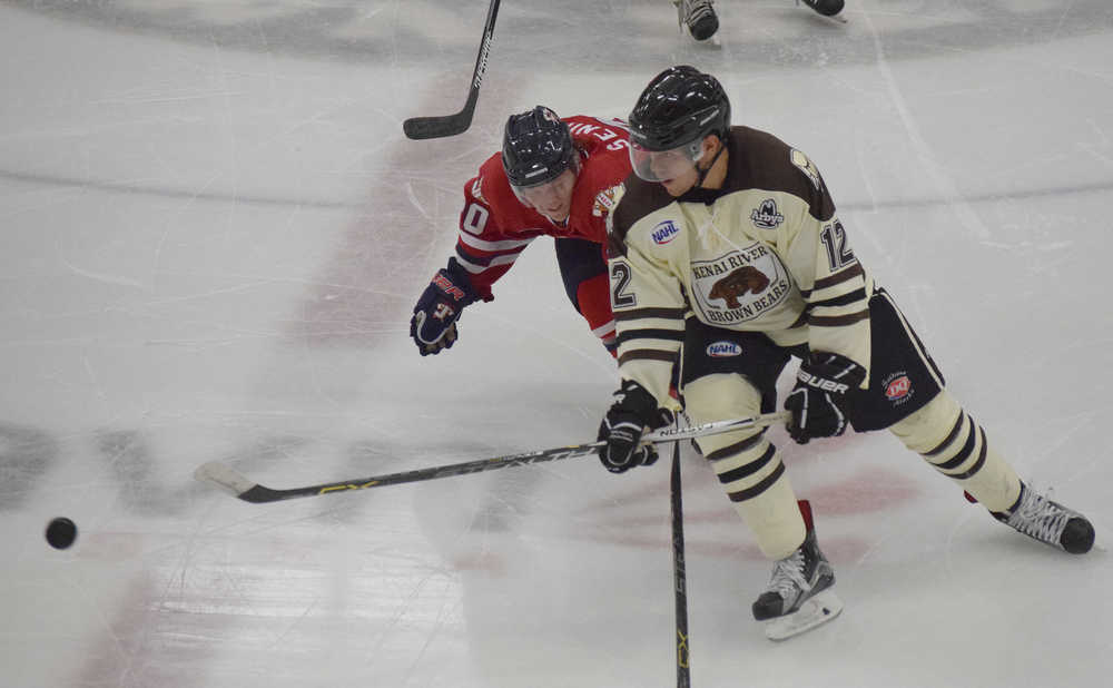 Photo by Joey Klecka/Peninsula Clarion Kenai River defenseman Jordan Holmes (12) deflects the puck away from Johnstown forward Tiernan Seningen Wednesday night at the Soldotna Regional Sports Complex.