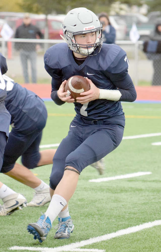 Photo by Jeff Helminiak/Peninsula Clarion Soldotna quarterback Brandon Crowder hands off in the game against Kenai Central on Saturday at Justin Maile Field in Soldotna. Crowder broke his foot in the game and will be out for the postseason.