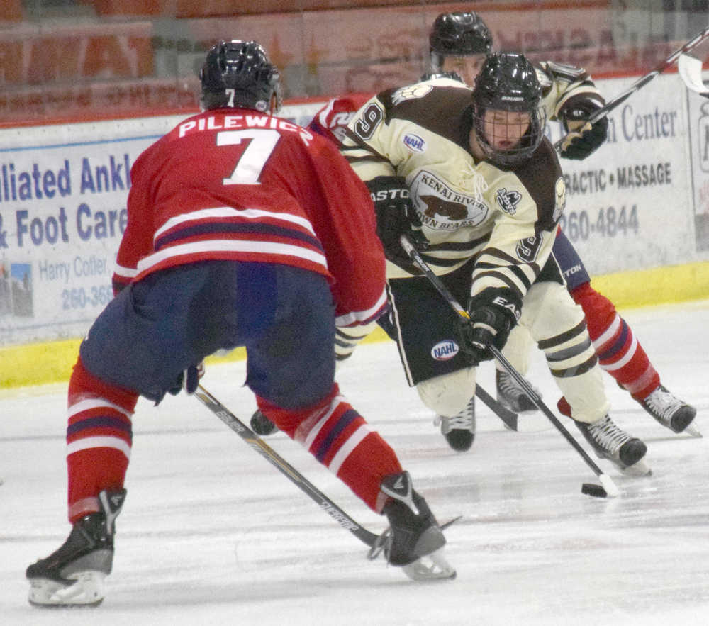 Photo by Jeff Helminiak/Peninsula Clarion Kenai River forward Evan Butcher skates the puck up the ice against Johnstown (Pennsylvania) defenseman Adam Pilewicz on Friday at the Soldotna Regional Sports Complex.