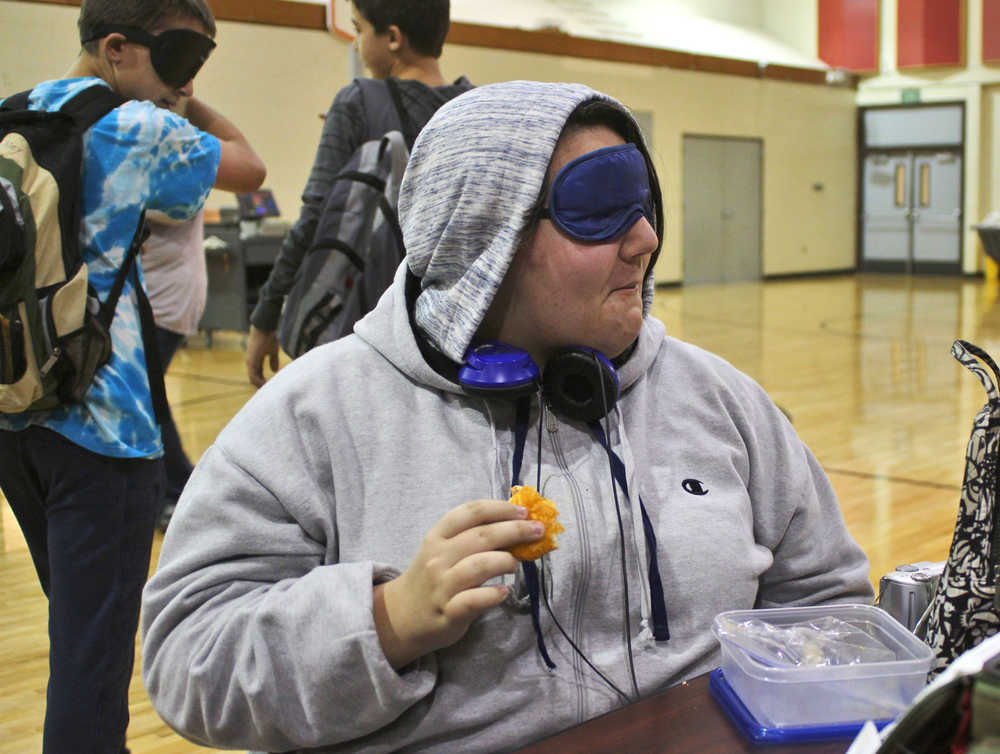 Ben Boettger/Peninsula Clarion Calysa Saporito-Mills eats lunch blindfolded in the River City Academy gym/cafeteria during the Blindness Challenge on Thursday, Oct. 13 in Soldotna.