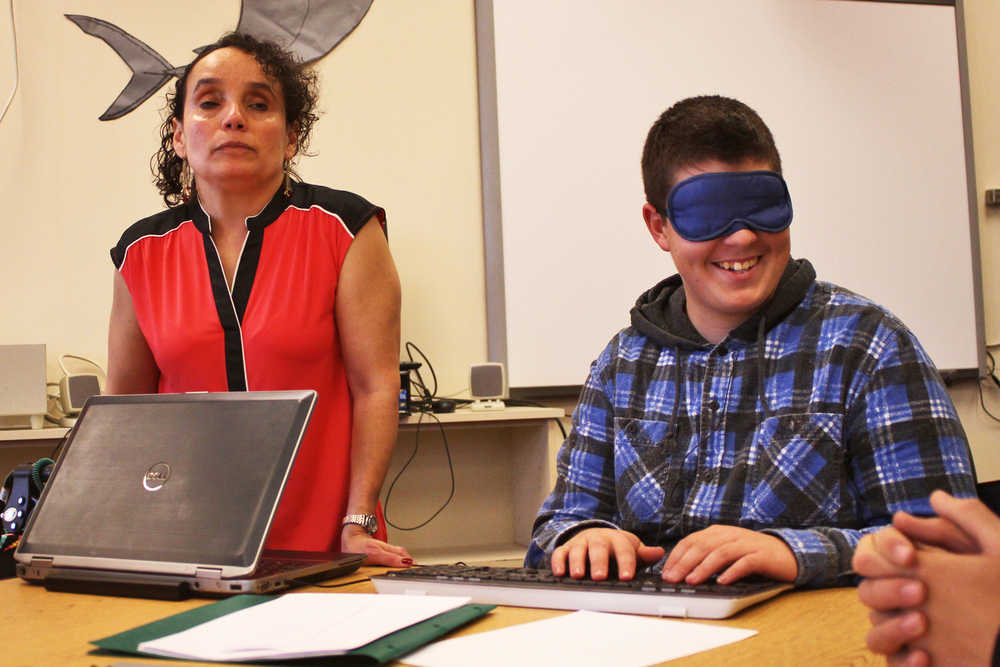 Photo by Ben Boettger/Peninsula Clarion Kenai Peninsula Borough School District teacher for the visually-impaired Jordana Engebretson (left) helps blindfolded student Steven Smith type a message on her computer, which has a text-to-speech program that reads back the letters and words Smith types, during RIver City Academy's Blindness Challenge on Thursday, Oct. 13 in Soldotna.