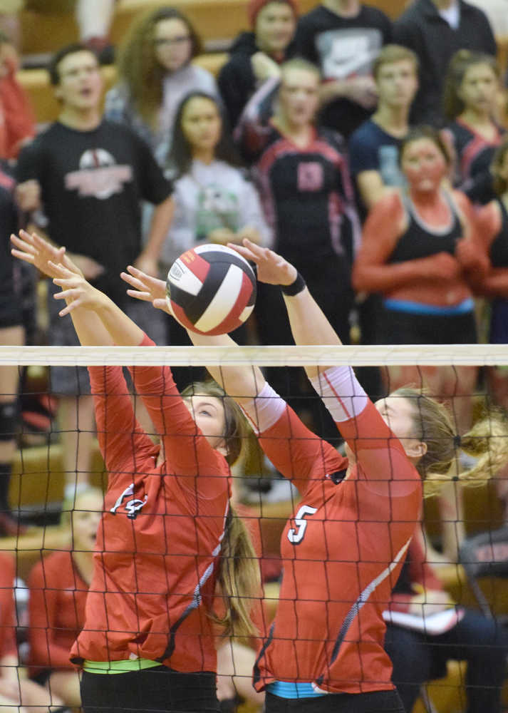 Photo by Jeff Helminiak/Peninsula Clarion Samantha Kompkoff and Emily Koziczkowski combine for a stuff block against Wasilla in front of a charged-up student body Friday night at Kenai Central.