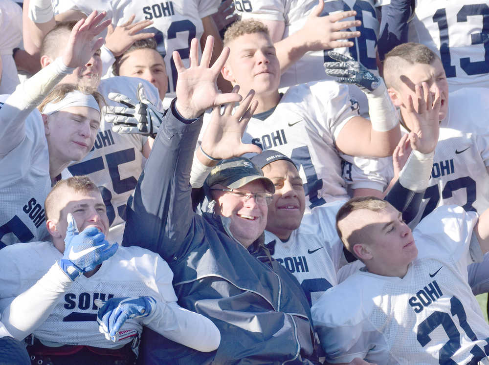 Photo by Joey Klecka/Peninsula Clarion Soldotna head coach Galen Brantley Jr. (center with dark jacket) celebrates with his players after winning a school-record fifth straight state football championship Saturday at Palmer High School. The Stars defeated the Palmer Moose 49-13.