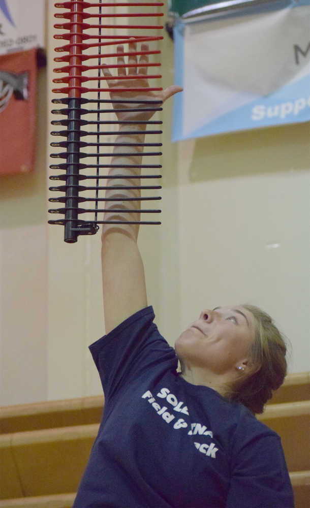 Photo by Joey Klecka/Peninsula Clarion Soldotna senior Annie Quinn makes her mark in the vertical challenge Wednesday night at Kenai Central High School.