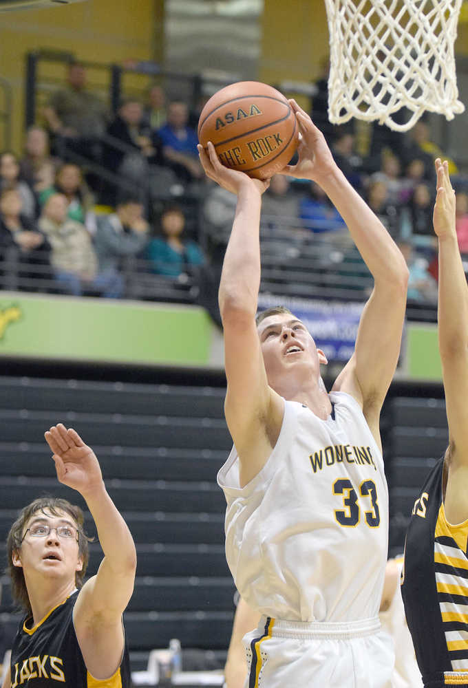 Photo by Joey Klecka/Peninsula Clarion Ninilchik forward Austin White (33) shoots amid a scrum of King Cove defenders in March 2015 at the Class 1A March Madness state tournament at the Alaska Airlines Arena in Anchorage.