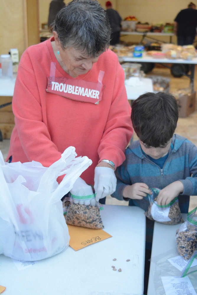 Kaye Fariday helps a boy /name??// from Fireweed Academy bag food at the Homer Food Pantry on Sept. 26 at Homer United Methodist Church.