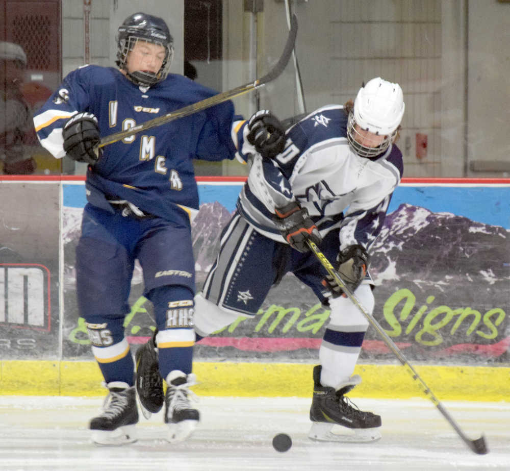 Photo by Jeff Helminiak/Peninsula Clarion Homer's Tim Blakely and Soldotna's Braxton Urban try to corral the puck Friday in the Peninsula Ice Challenge at the Soldotna Regional Sports Complex.