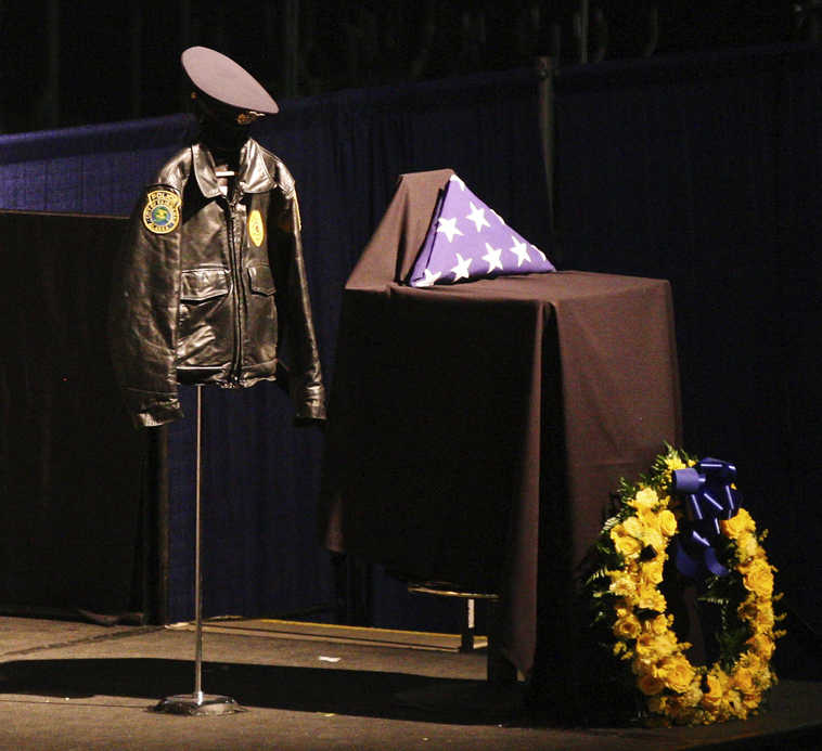 In this Sunday, Nov. 6, 2016, photo, Fairbanks Police Department Sgt. Allen Brandt's uniform appears on stage during the funeral for Brandt at the Carlson Center in Fairbanks, Alaska. Hundreds of mourners including Gov. Bill Walker paid their respects Sunday at the funeral of the Fairbanks police officer killed in the line of duty. (Eric Engman/Fairbanks Daily News-Miner via AP)