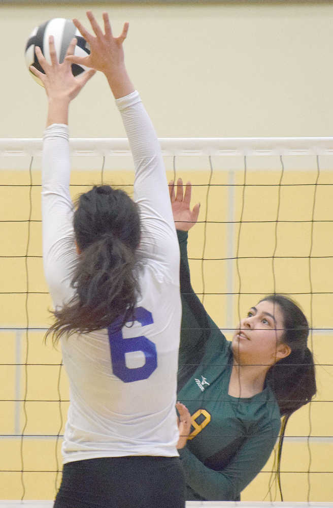 Photo by Joey Klecka/Peninsula Clarion Seward setter Ashley Jackson sends a ball into the clutches of Barrow's Ana Stringer, Thursday morning at the Class 3A state volleyball tournament at the Alaska Airlines Arena in Anchorage.